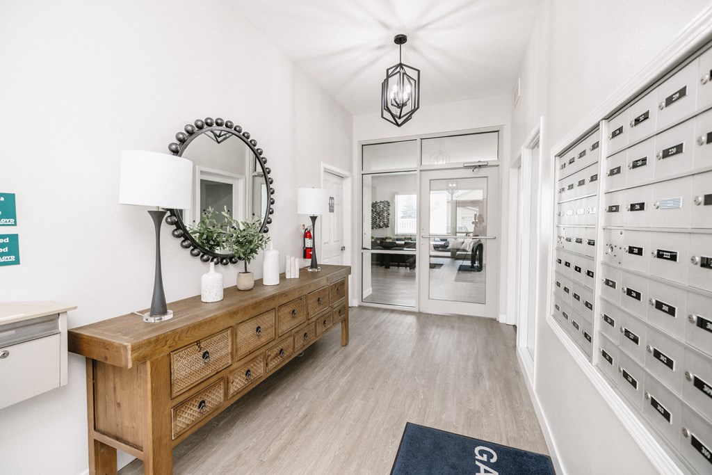 a hallway with a dresser and a mirror in a white room
