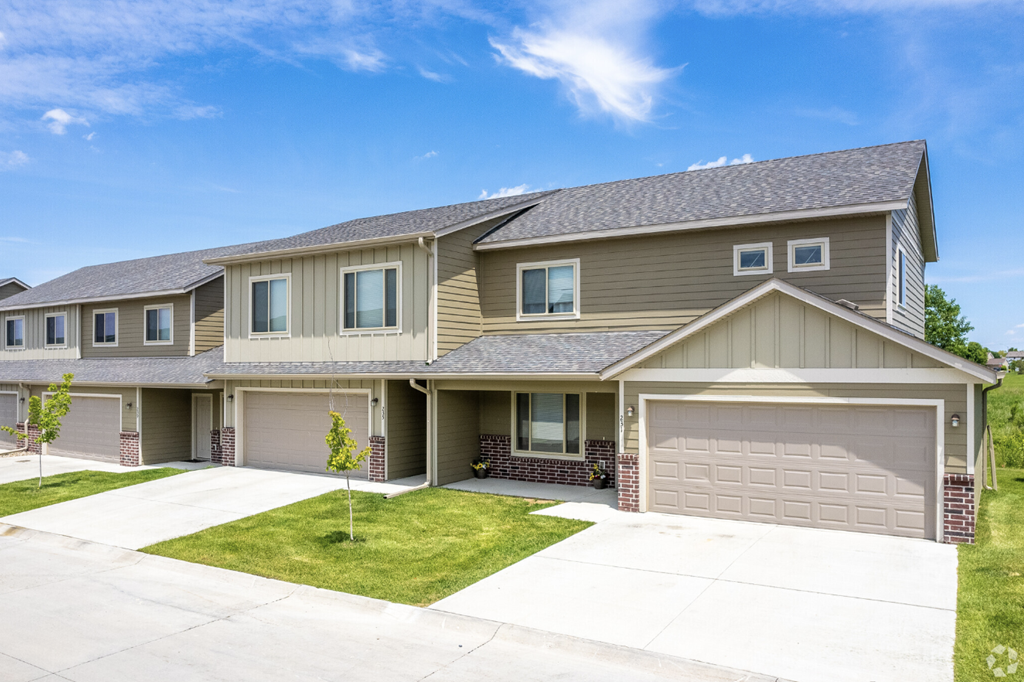 Well-maintained landscaping with manicured shrubs and paved walkways.