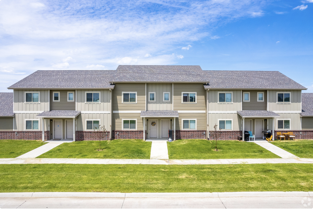 Well-maintained landscaping with manicured shrubs and paved walkways.