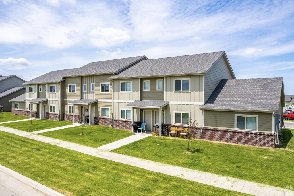 Well-maintained landscaping with manicured shrubs and paved walkways.