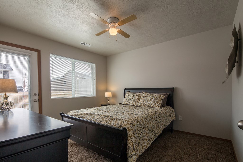 a bedroom with a bed and a ceiling fan