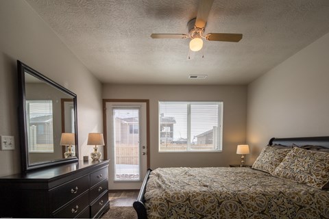 a bedroom with a large bed and a ceiling fan