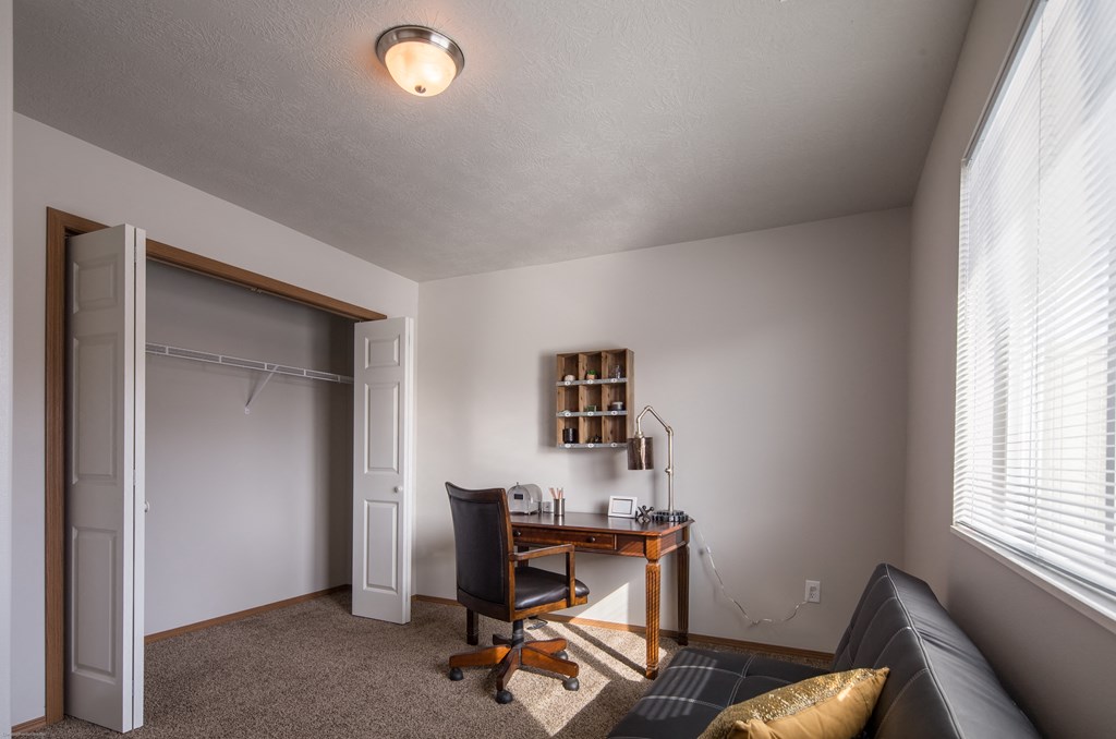 an office with a desk and a door to a closet
