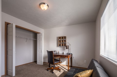 an office with a desk and a door to a closet