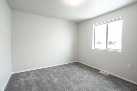 an empty room with carpet and a window