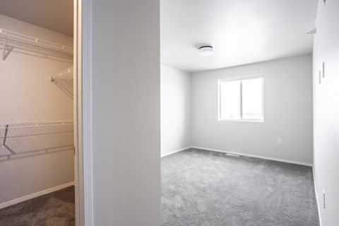 an empty bedroom with a closet and a window