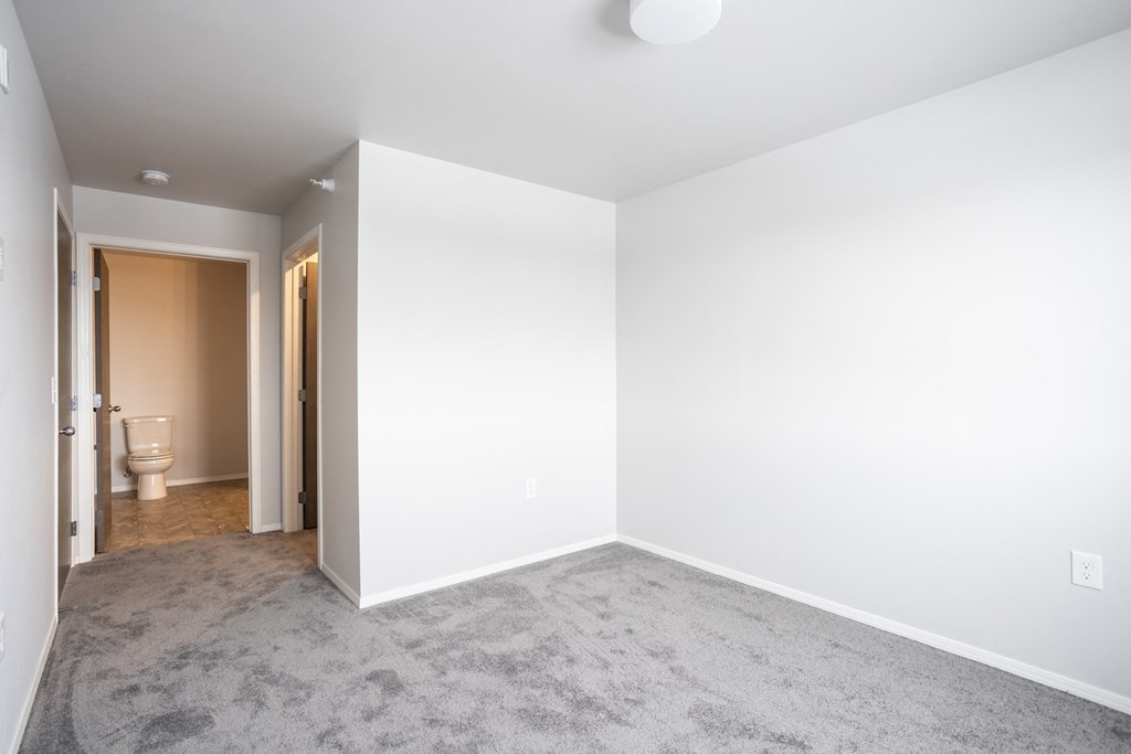 an empty room with a toilet and a white wall