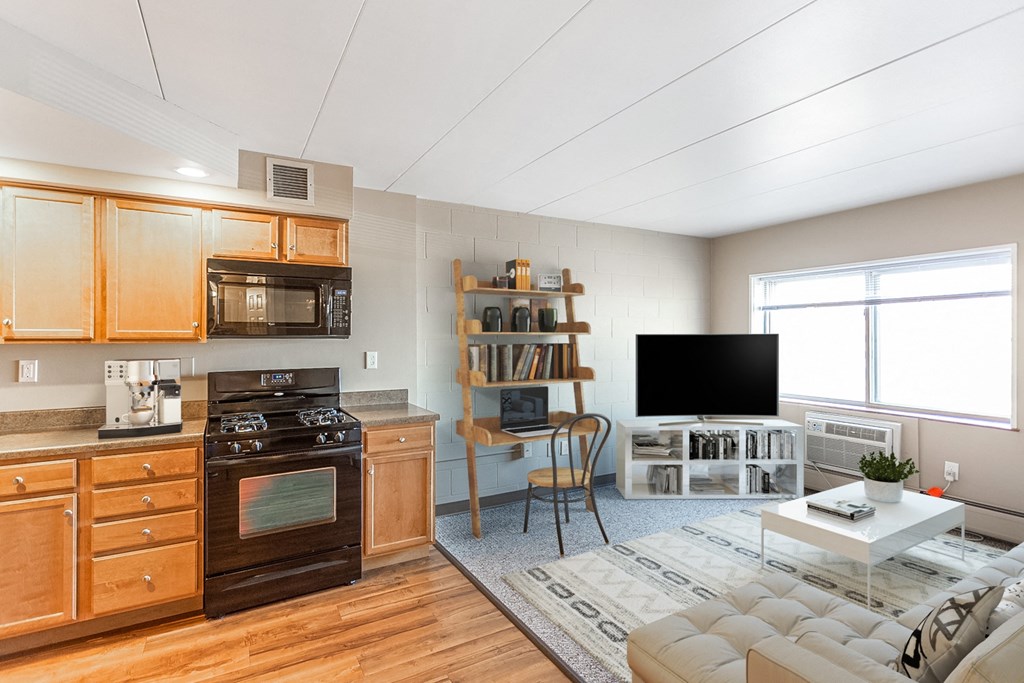 a kitchen and living room with wooden cabinets and appliances and a television