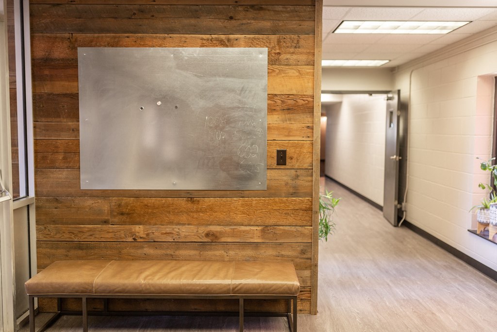 a bench and a painting on a wall in a hallway