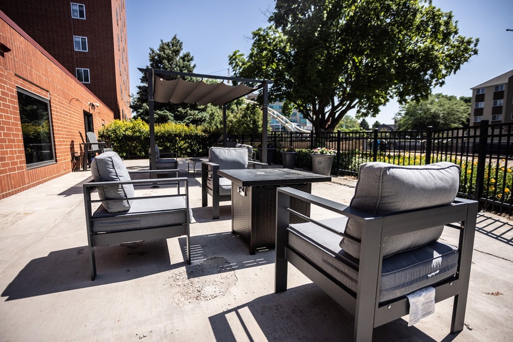 an outdoor patio with chairs and a table and a umbrella
