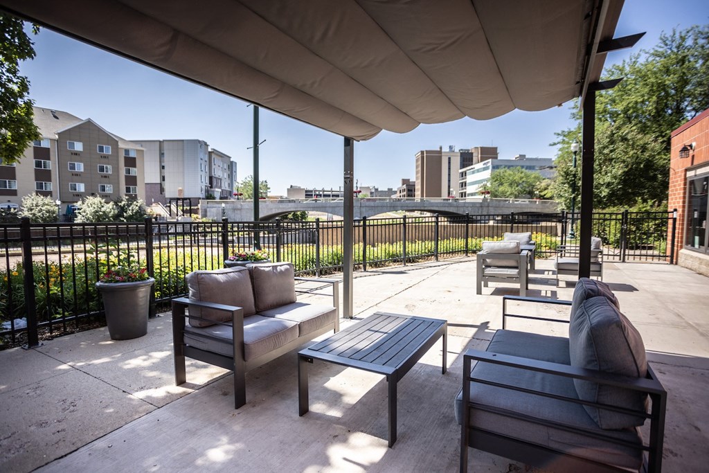 an outdoor patio with chairs and tables and a city in the background