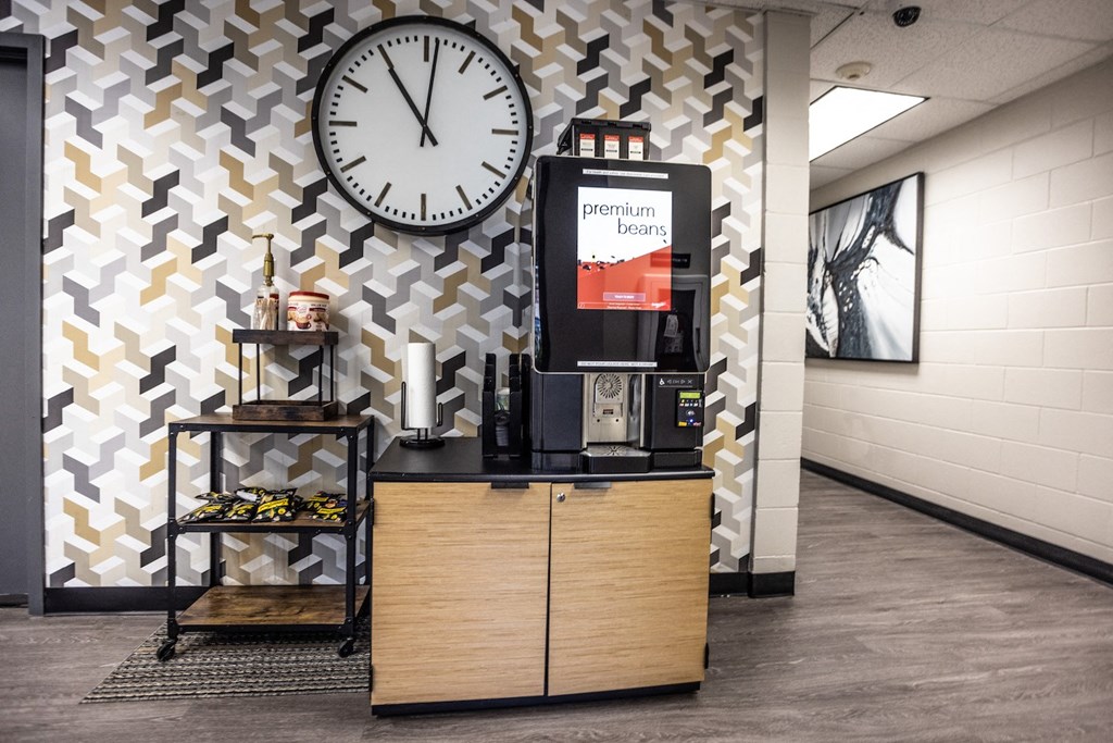 a lobby with a clock on the wall and a coffee machine