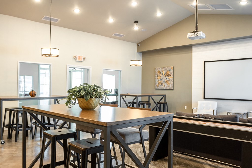 a dining room with a table and chairs and a projection screen