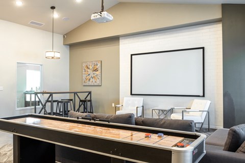 a game room with a pool table and a projection screen