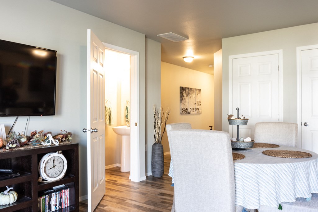a living room and dining room with a table and a tv