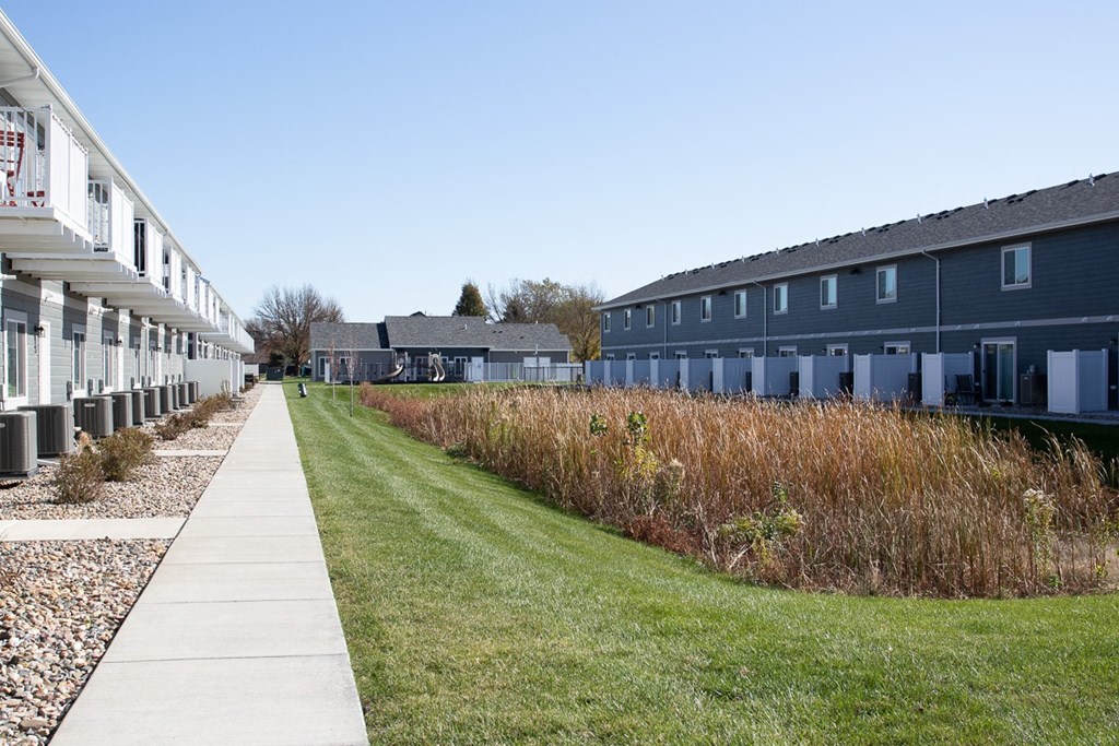 a row of houses on the side of a sidewalk