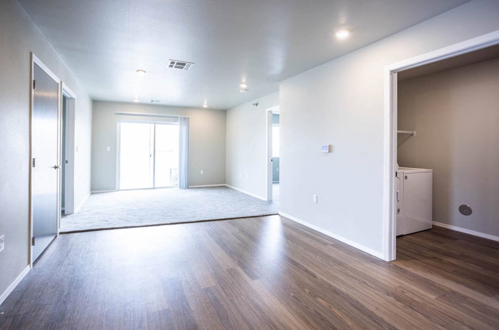 an empty living room with white walls and wood floors