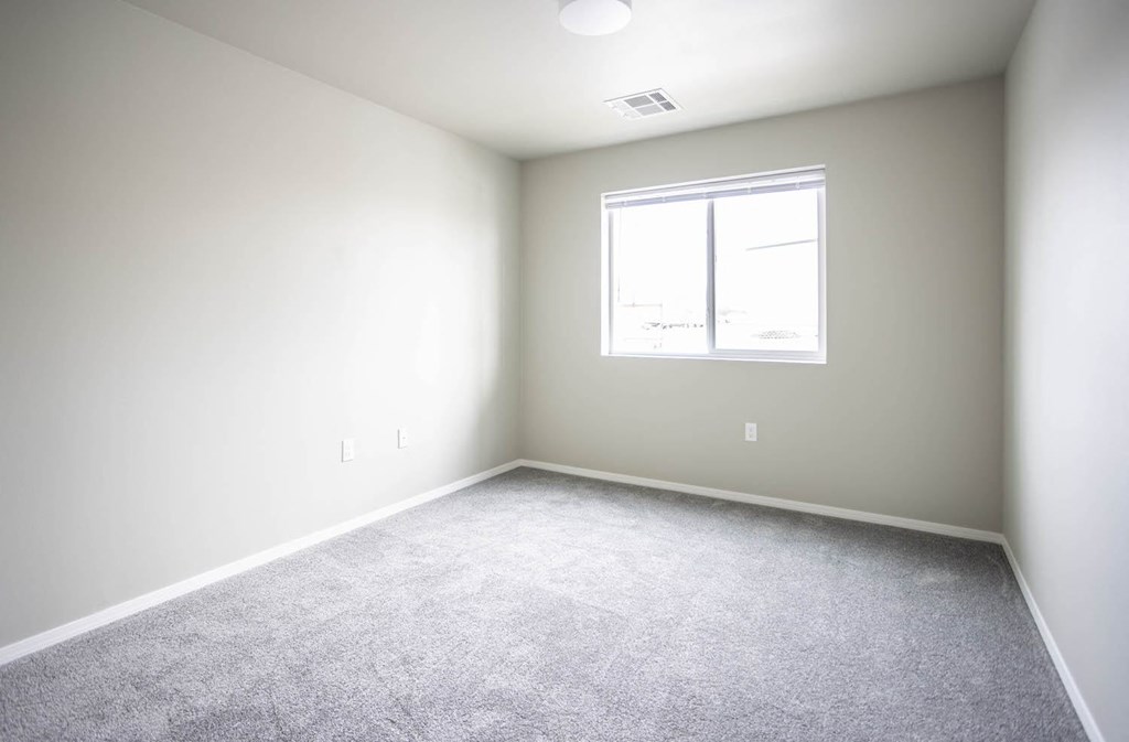 an empty room with white walls and a window
