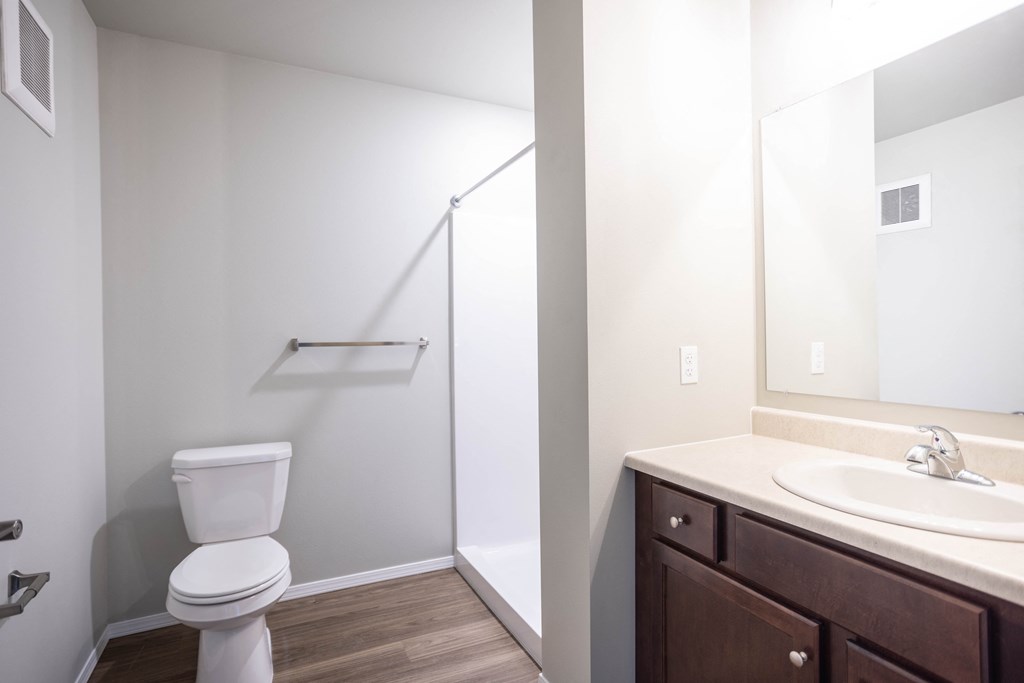 a bathroom with a toilet sink and shower and a mirror