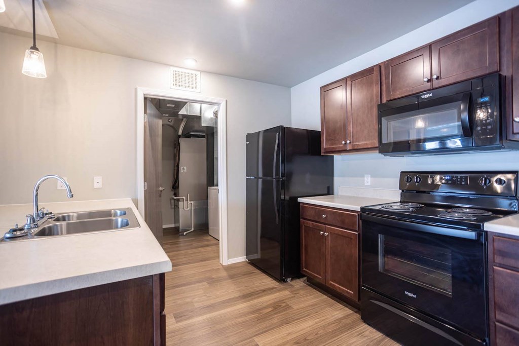 a kitchen with black appliances and wooden cabinets