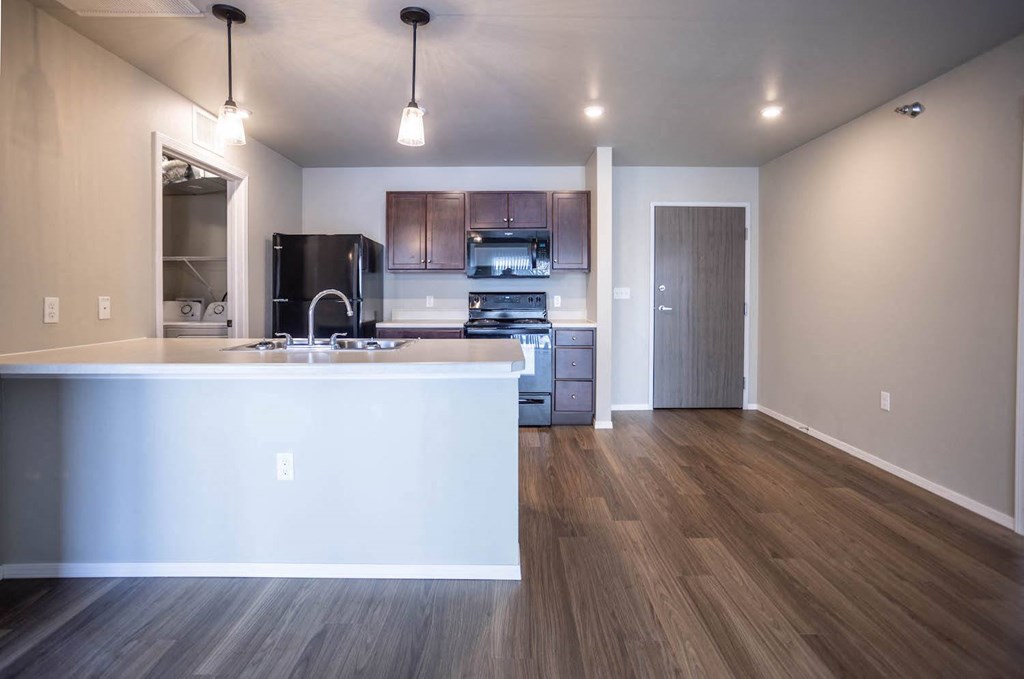 a kitchen and living room with a white counter top