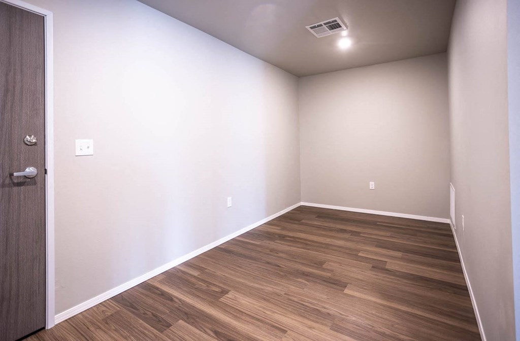 a empty room with wood flooring and white walls