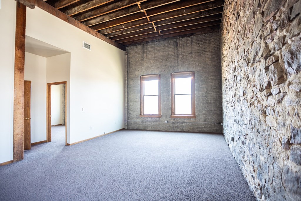 an empty room with a stone wall