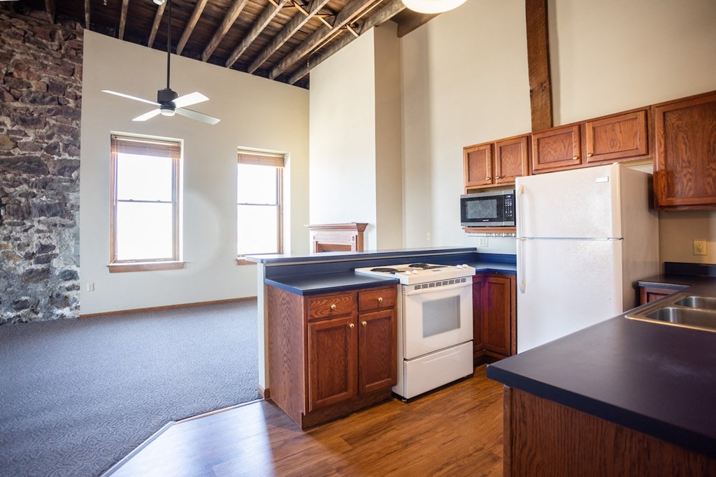 an empty kitchen with wooden cabinets and a white refrigerator