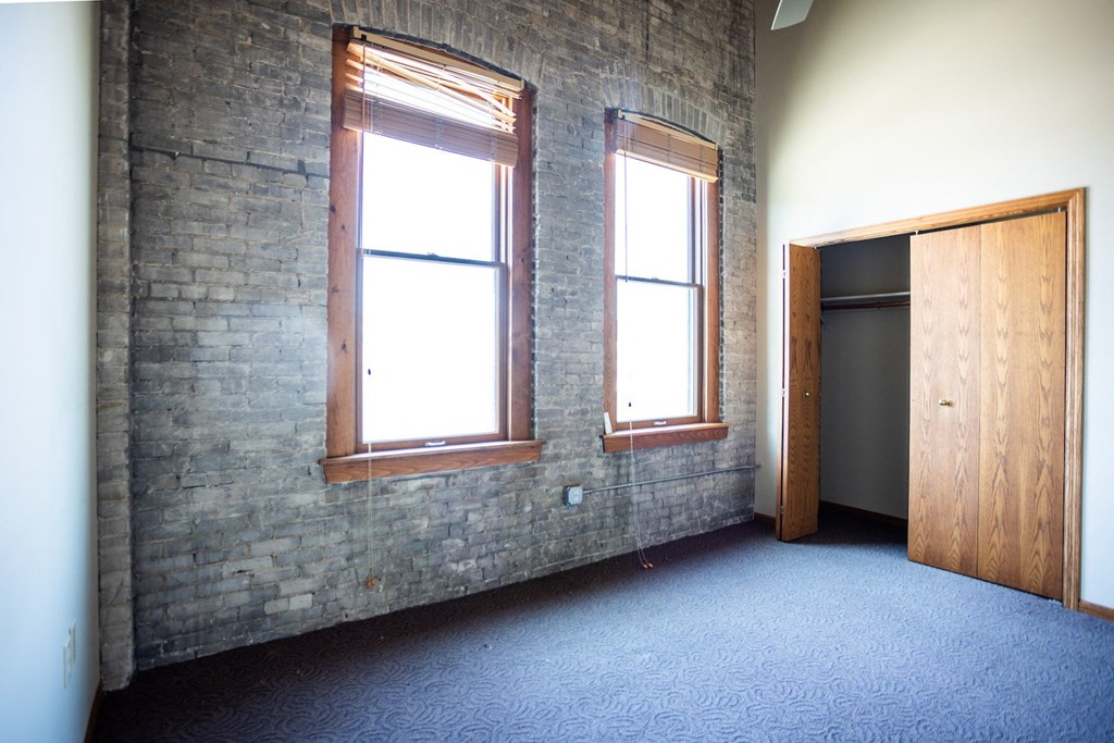 an empty room with two windows and a door