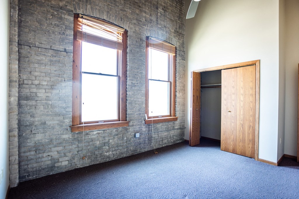 an empty room with two windows and a door