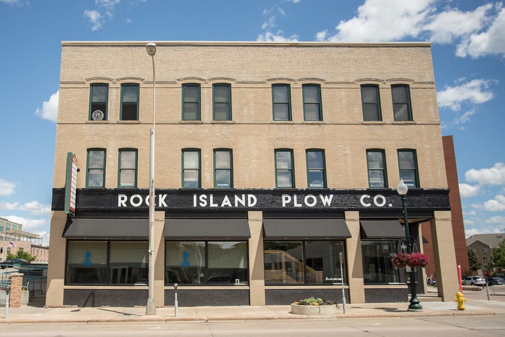 the front of the rock island plow company building on the corner of a street