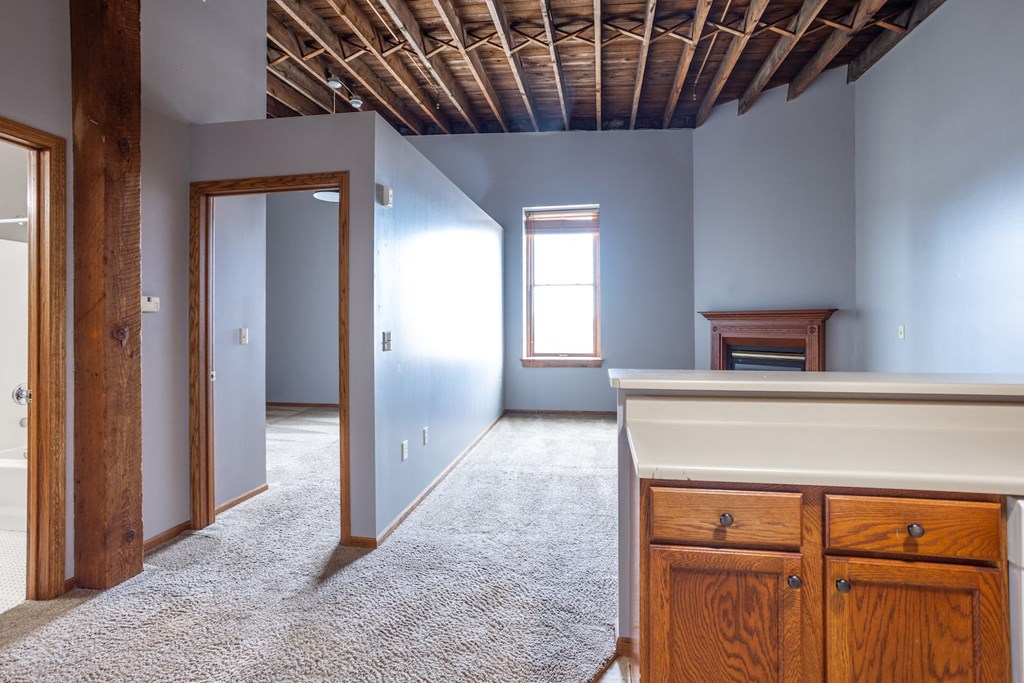 an empty room with blue walls and a white counter and a door to a bedroom