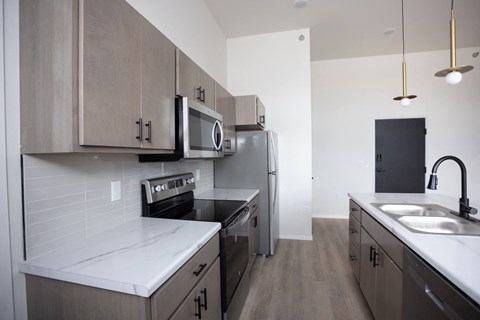 A kitchen with a white counter top and wooden cabinets.