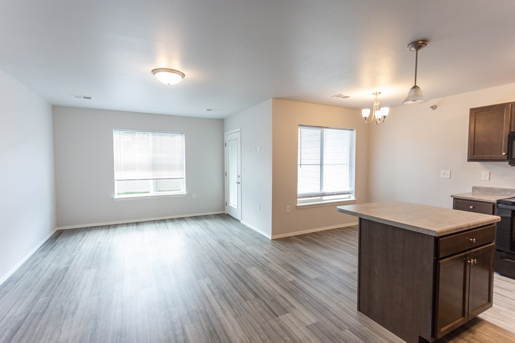 the view of a living room and kitchen in an empty apartment