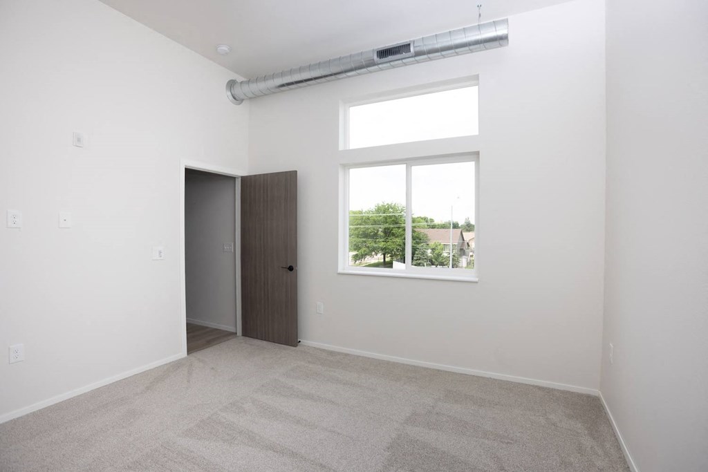 an empty room with a large window and a closet