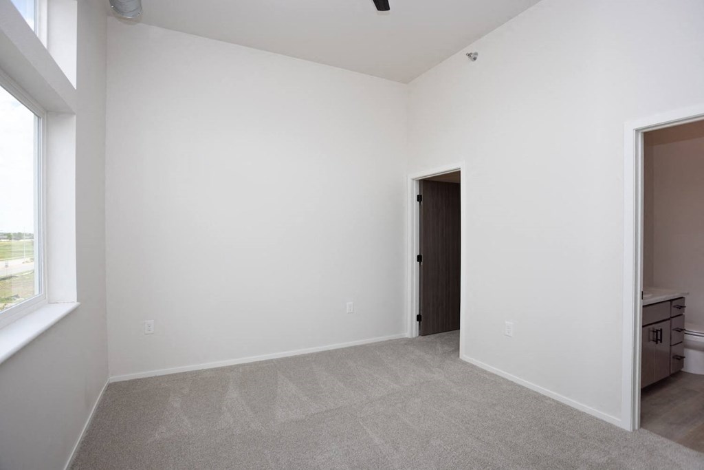 a bedroom with white walls and a door to a closet