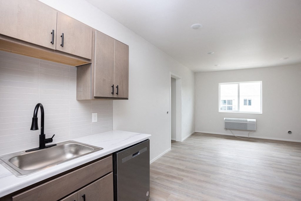 a kitchen and living room with a sink and a window