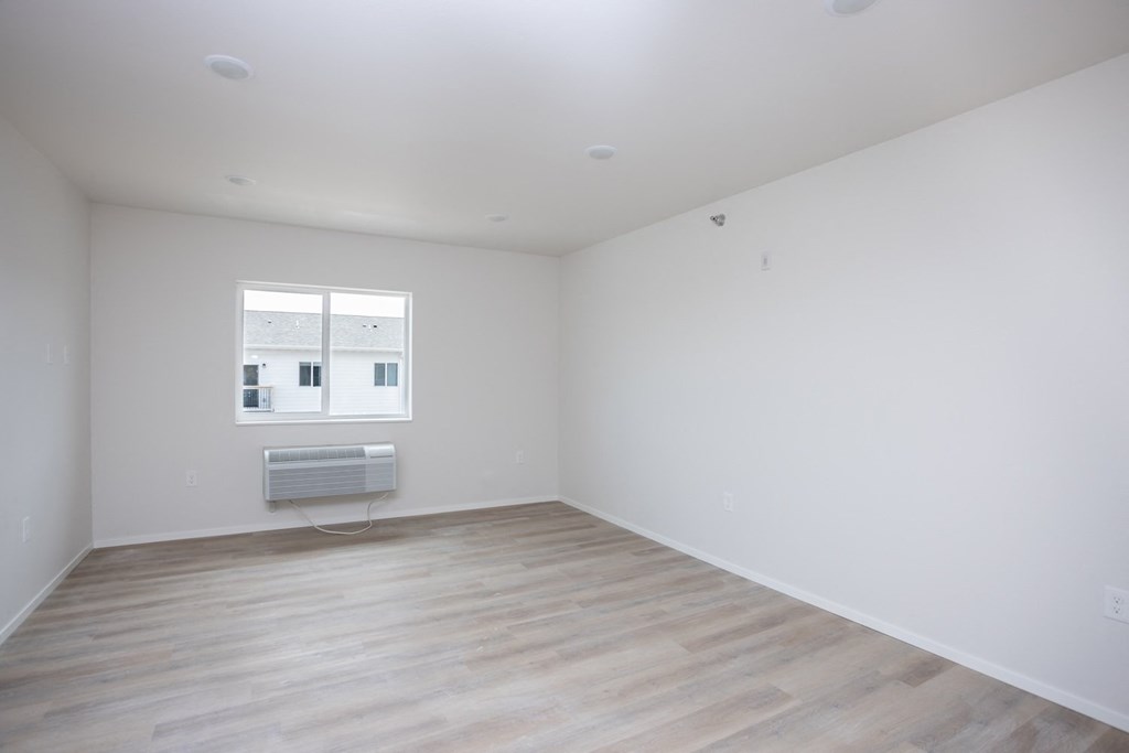 an empty room with white walls and a window