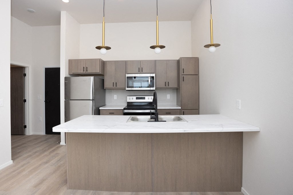 a kitchen with a large island and stainless steel appliances