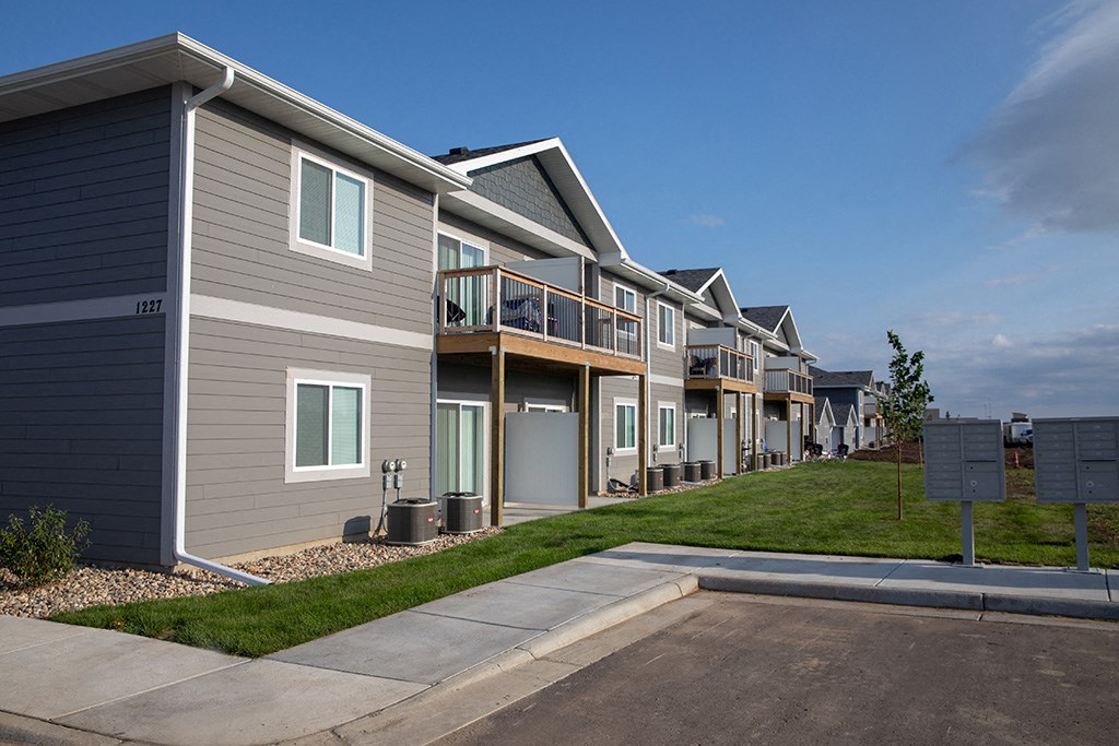a row of townhomes with balconies and a sidewalk