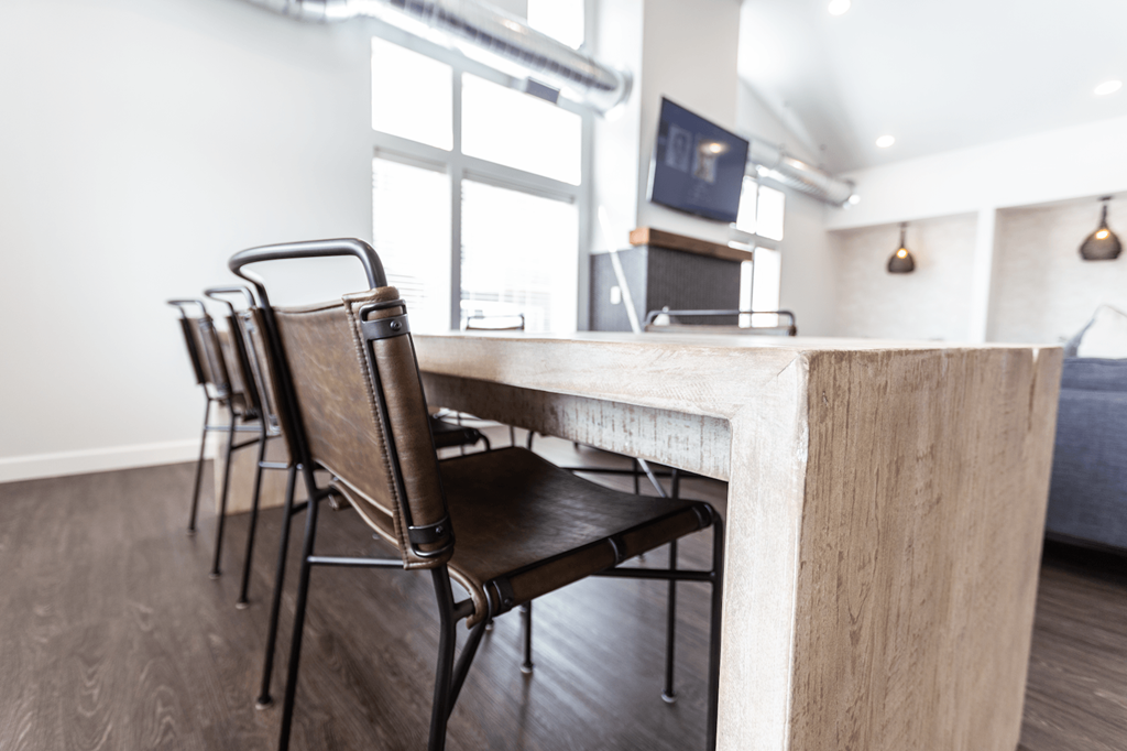 a bar with chairs in a room with a couch and a tv
