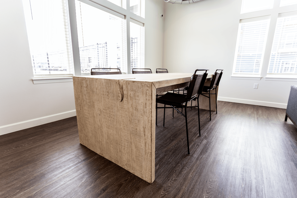 an office with a desk and chairs in front of some windows