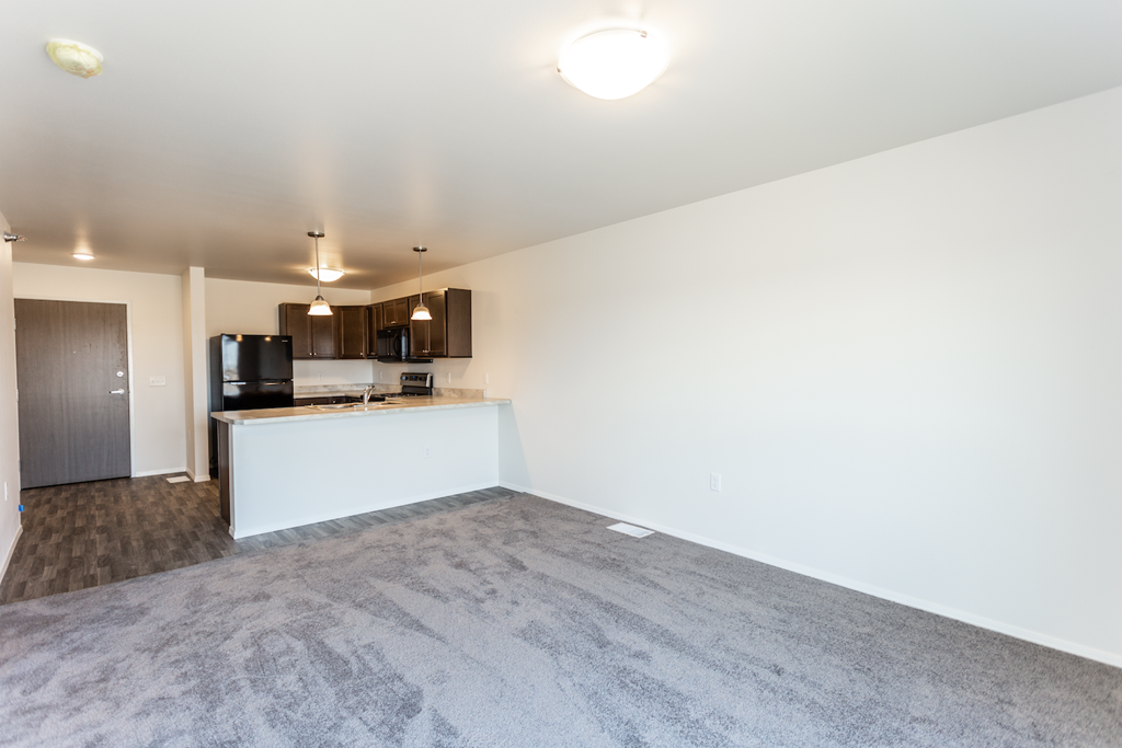 A spacious room with a grey carpet and a white reception desk.