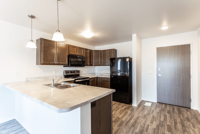 an empty kitchen with a sink and a refrigerator