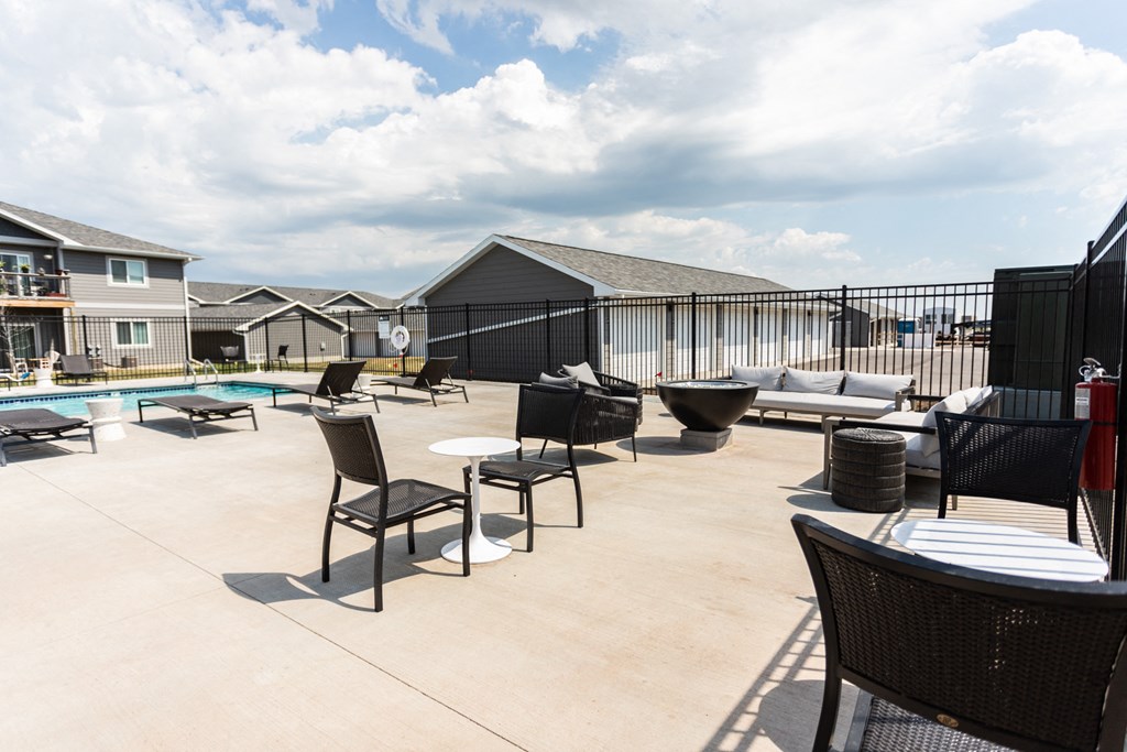 an outdoor patio with tables and chairs and a swimming pool