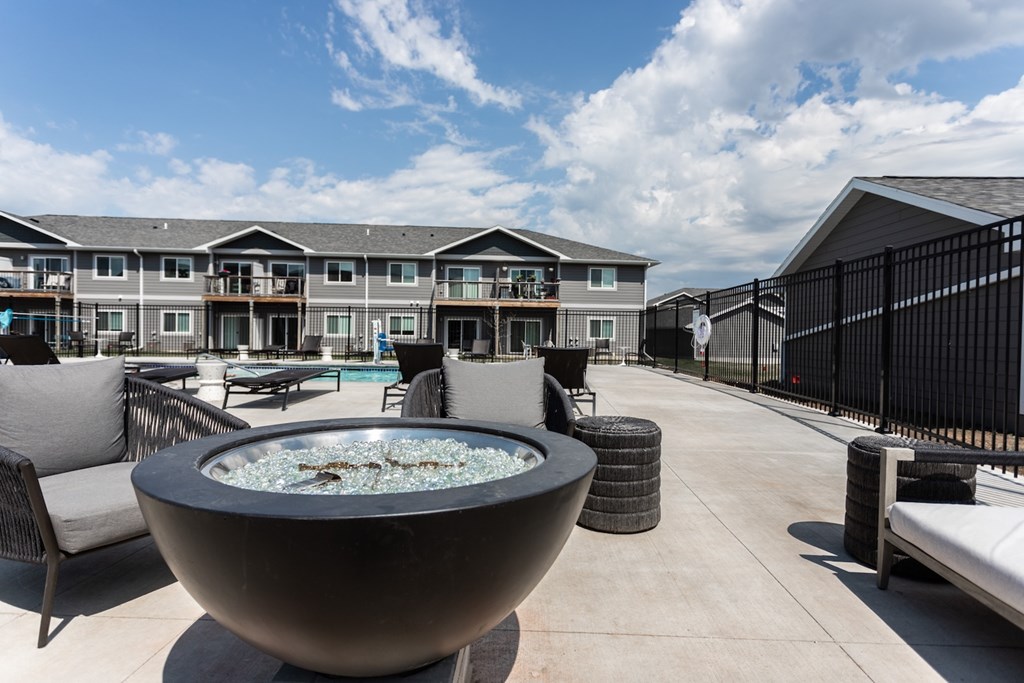 A large fountain is the centerpiece of a patio area in front of a building.