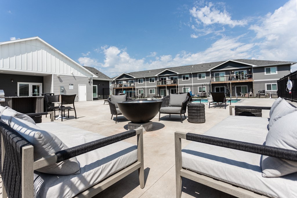 a large patio with furniture and a fire pit