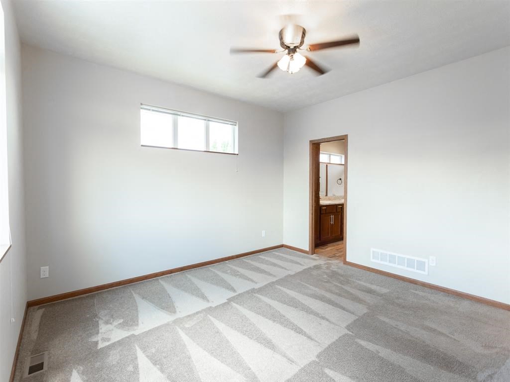 an empty living room with a ceiling fan
