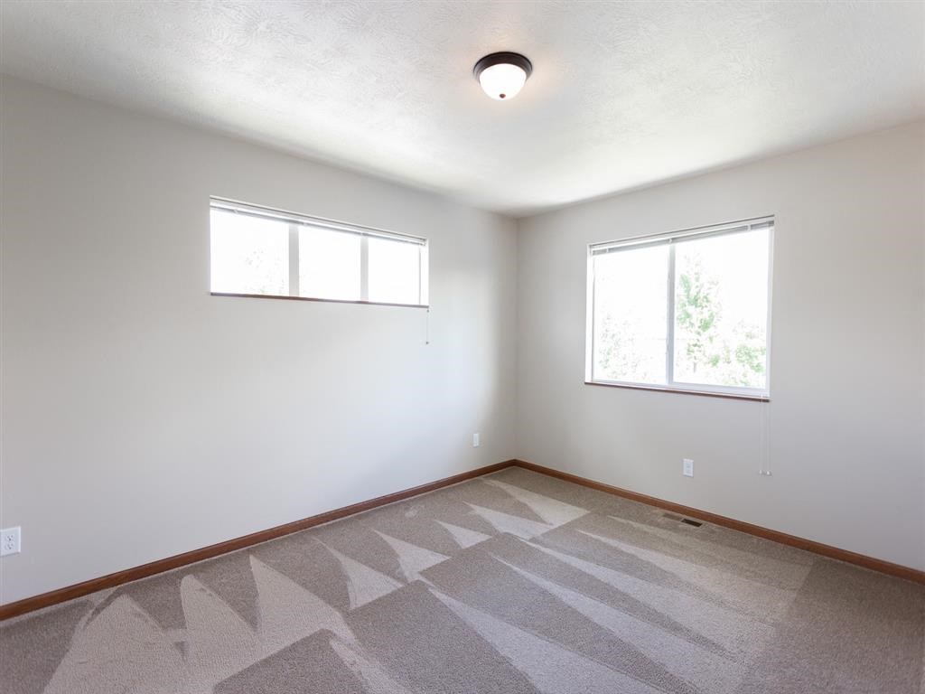 the living room of an empty house with two windows