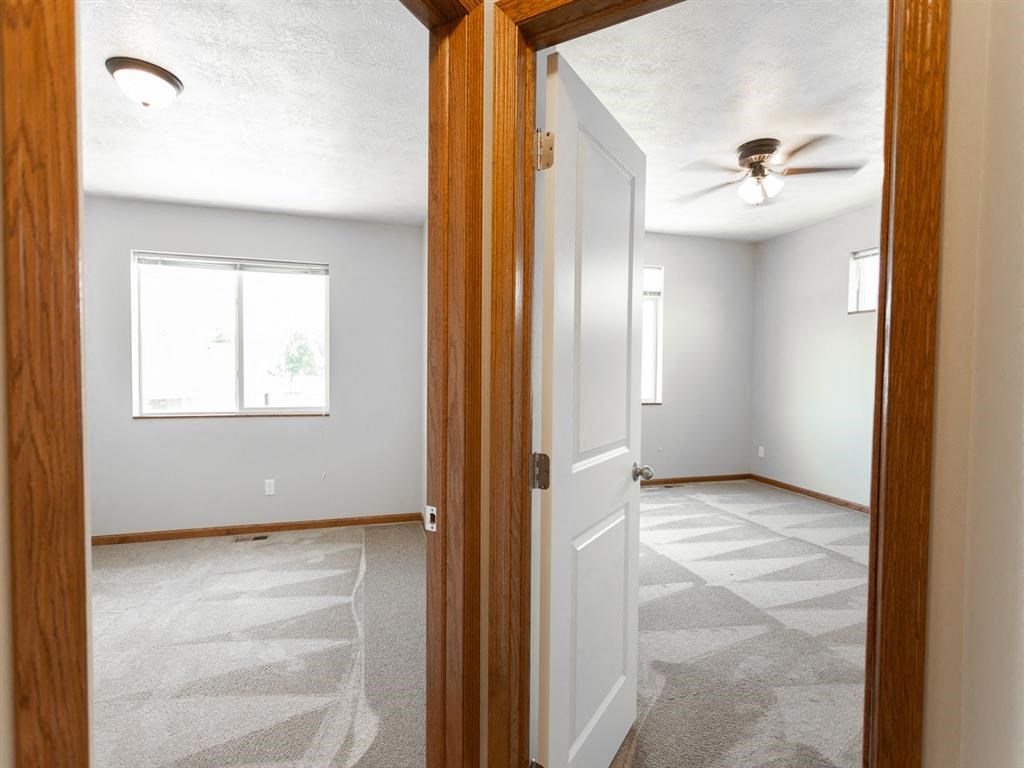 an empty living room with a ceiling fan in it